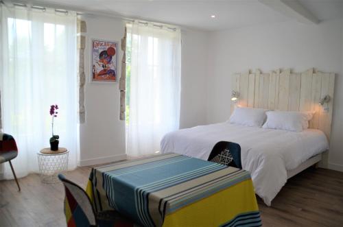 - une chambre avec un lit blanc et un banc dans l'établissement Maison d'hôtes City Break MIRADOUR, à Bayonne