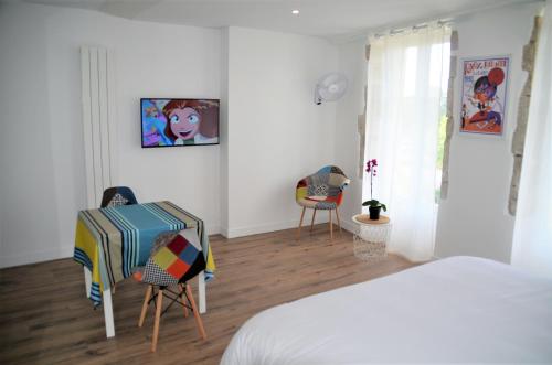 a bedroom with a bed and two chairs and a table at Maison d'hôtes City Break MIRADOUR in Bayonne