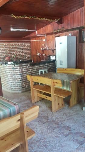 cocina con mesa de madera grande y nevera en На гости при Силвия, en Obzor