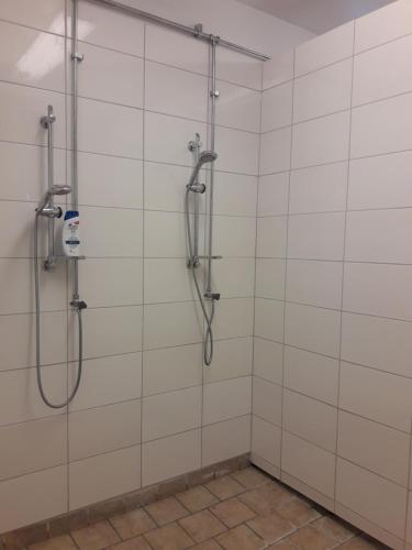 y baño con ducha y azulejos blancos. en Körsbärskullen en Vimmerby