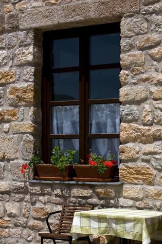 a window with two potted plants and a table in front of it at Kalin Hotel in Lazaropole