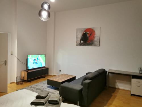 ein Wohnzimmer mit einem Sofa und einem TV in der Unterkunft Stay Inn Braunschweig in Braunschweig