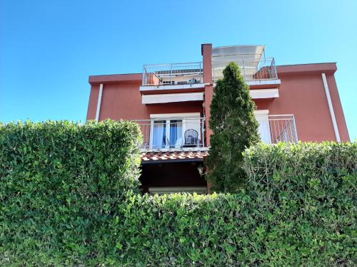 a building with a hedge in front of it at Ferienwohnung KRK Peter Lindpointner in Krk