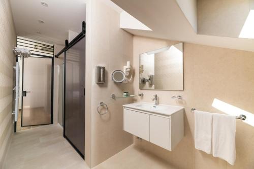 a bathroom with a sink and a shower at BO Hotel Palazzo in Poreč