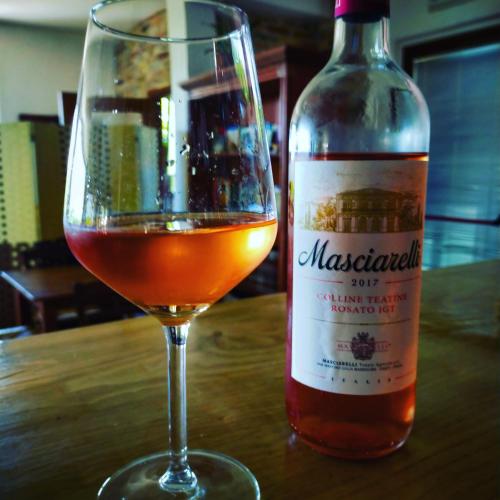 a bottle of wine sitting next to a wine glass at Casale del Sole in Cepagatti
