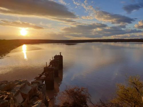 a large body of water with the sun setting at Teri-Lemveli Lodge in Beaufort West