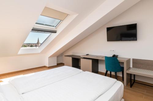 a bedroom with a bed and a desk and a tv at BO Hotel Palazzo in Poreč