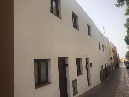 a white building with black windows on a street at Fuerteventura Family Luxury in Morro del Jable