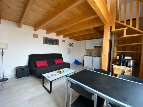 uma sala de estar com um sofá e uma mesa em CENTRE CHATELAILLON GRAND LOFT ** 100m DE LA PLAGE em Châtelaillon-Plage