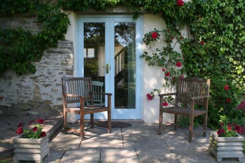 two chairs sitting in front of a door with flowers at Munden House in Sherborne