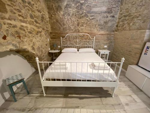 a bedroom with a white bed in a brick wall at Le volte nel borgo in Termoli