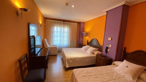 Cette chambre comprend deux lits et une télévision. dans l'établissement Tierra De Lobos, à Puebla de Sanabria