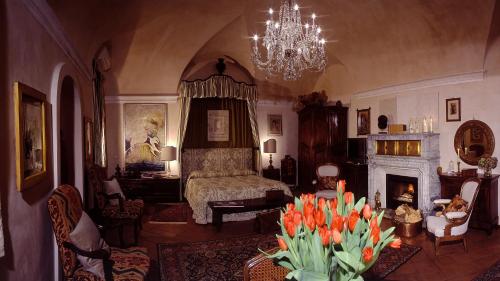 uma sala de estar com uma cama e uma lareira em Castello Di Strambinello em Strambinello