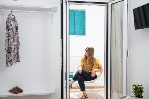 a woman sitting in a chair in front of a mirror at Unique Anoi House - In the Heart of Skyros Village in Skiros