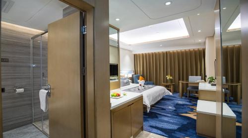 ein Hotelzimmer mit einem Bett und einem Bad in der Unterkunft Kunming Golden Spring Hotel in Kunming