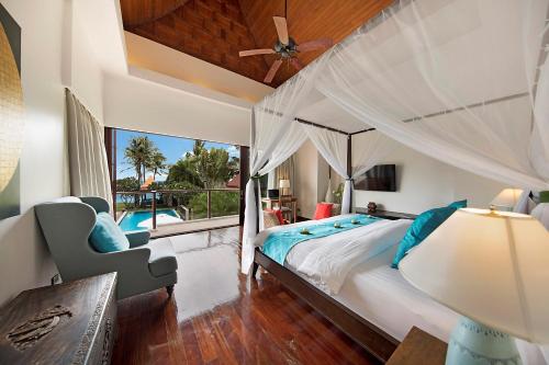 - une chambre avec un grand lit et un ventilateur de plafond dans l'établissement Dhevatara Cove, à Lipa Noi