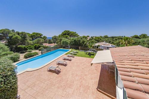 a swimming pool with lounge chairs and an umbrella at Villa San Cristobal by 3VILLAS in Binibeca