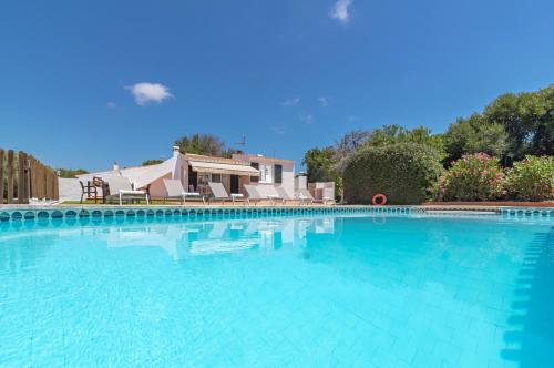 a large swimming pool with blue water at Villa San Cristobal by 3VILLAS in Binibeca