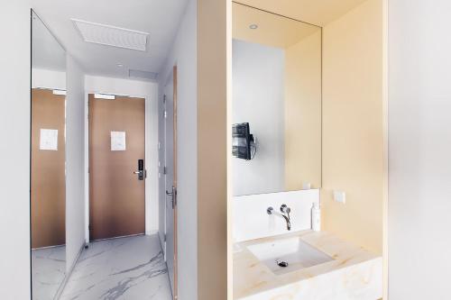 uma casa de banho com um lavatório e um espelho em 171. Urban Design Hotel em Roterdão