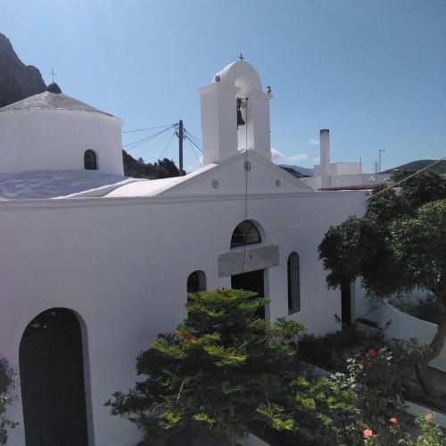 a white church with a tree in front of it at Unique Anoi House - In the Heart of Skyros Village in Skiros