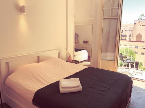 a bedroom with a bed with a towel on it at Big Bright New Apt next to Casino in Monte Carlo