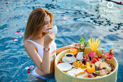 a woman sitting in a pool with a tray of food at Stellar of the Seas Cruise in Ha Long