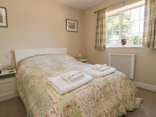a bedroom with a bed with towels on it at Fieldfare Lodge in Leyburn