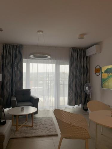 a living room with a couch and tables and a window at Aquamarina Prima Exclusive Suites in Międzyzdroje