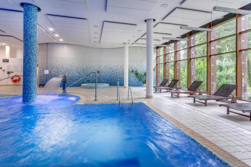 a pool with a water slide in a building at Holiday Inn Resort Warsaw Józefów, an IHG Hotel in Józefów