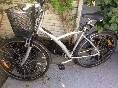 a bike with a basket parked outside a house at Loft Zen Climatisé in Soustons