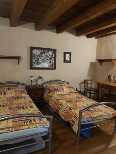 a bedroom with two beds and a table and chairs at Hostelskippy in Český Krumlov