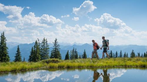 two people walking on a hill next to a lake at Haus Holzmann in Radstadt