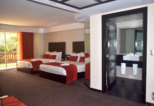 a hotel room with two beds and a sink at Savoy Hotel Boutique in Las Terrenas