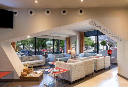 a living room with couches and a tv at Ribera de Triana Hotel in Seville