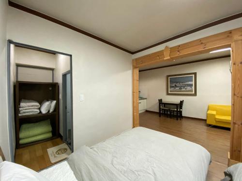 een slaapkamer met een bed en een kamer met een tafel bij Smile Resort in Sokcho