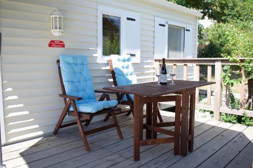una mesa de madera y 2 sillas en una terraza en Mobile Home Etang II, en Chiddes