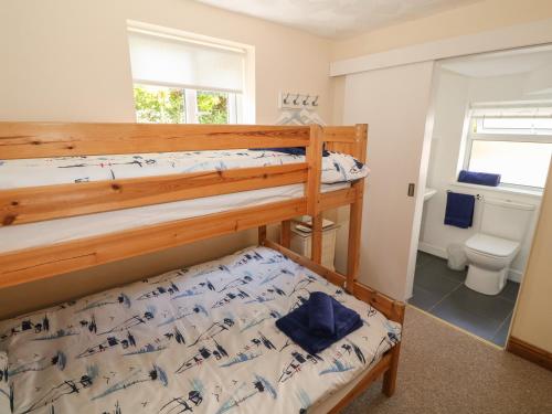 a bedroom with two bunk beds and a toilet at Min Y Traeth in Amlwch