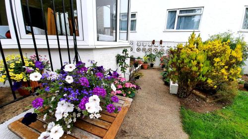 a bunch of flowers in front of a house at Le Chene Hotel in St Peter Port