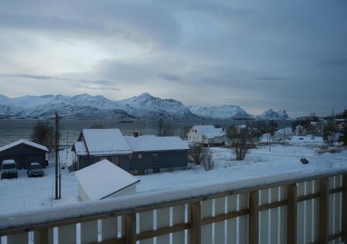a view of snow covered houses and mountains at Destination Senja - Skaland in Skaland
