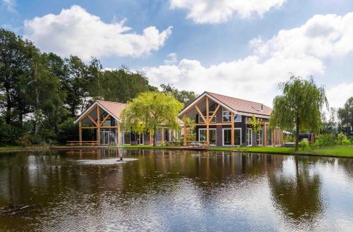 a house with a pond in front of it at TopParken – Résidence Lichtenvoorde in Lichtenvoorde