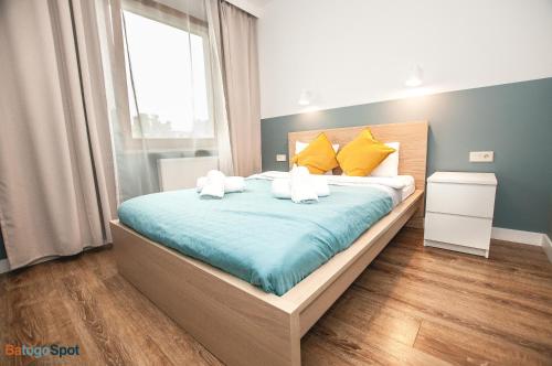 Schlafzimmer mit einem Bett mit gelber und blauer Bettwäsche in der Unterkunft BatogoSpot Tumski 2 in Breslau