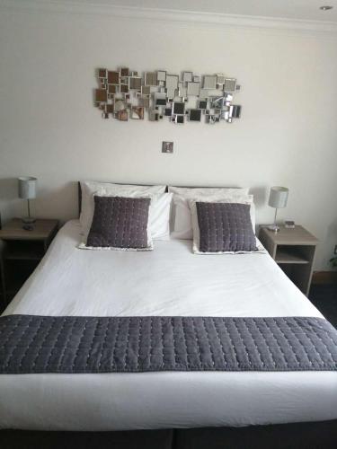 a large white bed with two pillows and two tables at Reveller Lodgings in Donegal