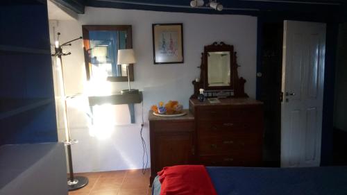 een slaapkamer met een spiegel, een dressoir en een lamp bij Tapada Flats in Viseu