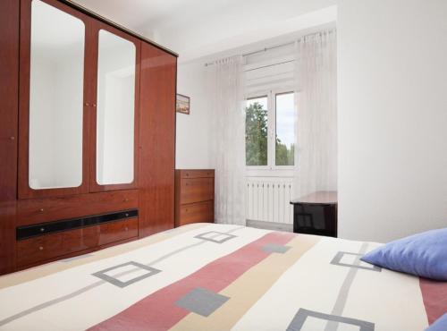 Bright apartment close to congress center & port في برشلونة: غرفة نوم بسرير وخزانة ونوافذ