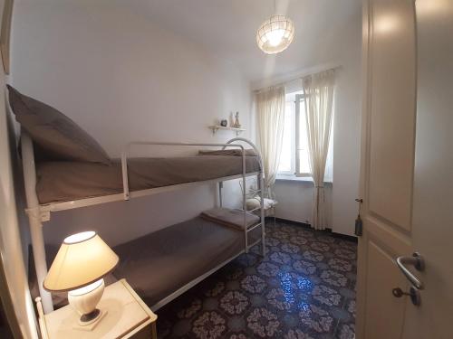 a room with two bunk beds and a table with a lamp at House La Baia delle Favole by Holiday World in Sestri Levante