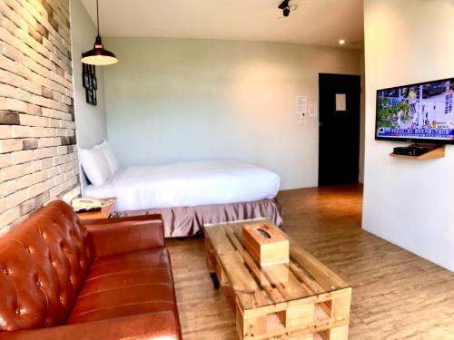 a living room with a couch and a tv at Martin Wales Inn in Kenting