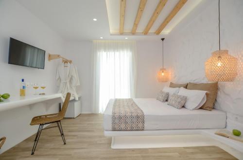 a white bedroom with a bed and a chair at Naxian Spirit Inn in Naxos Chora