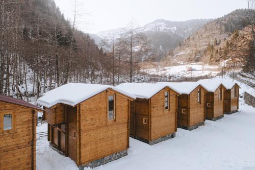 a row of wooden cabins in the snow at Sumda Konaklar in Çamlıhemşin