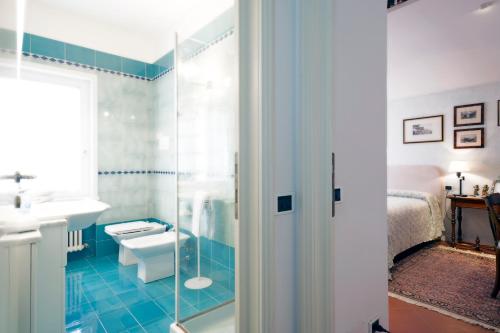a bathroom with a shower and a sink and a bed at Villa Bellaria B&B in Alseno