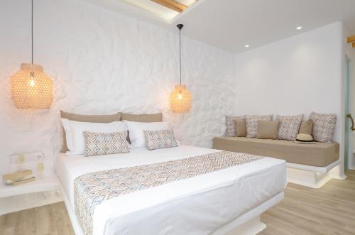 a white bedroom with a bed and a couch at Naxian Spirit Inn in Naxos Chora